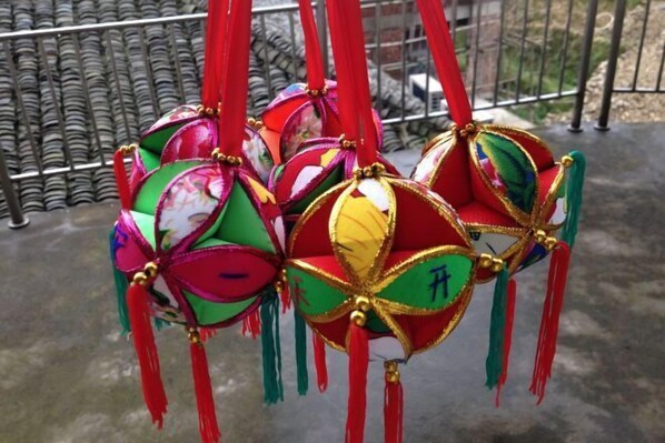 A set of colorful, decorative hanging ornaments with tassels and gold accents.