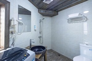 Ein Badezimmer mit Waschbecken, Spiegel, Dusche und Toilette.
