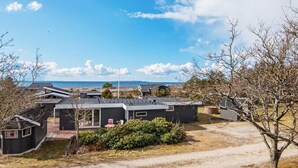 A modern house with a large deck, a small garden, and a view of the sea. - 6 Person Holiday Home in Logstor (Logstor)