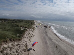 Una playa con dunas y un cielo despejado.