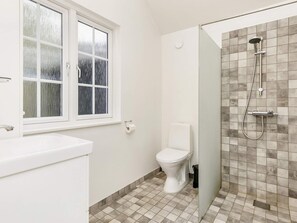 A bathroom with a toilet, a sink, a window, and a shower area. - 6 Person Holiday Home in Laeso (Læsø)