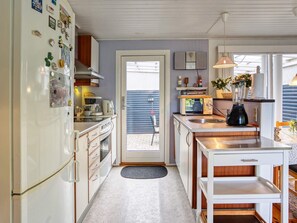 Una cocina compacta con refrigerador, microondas, estufa y lavaplatos.