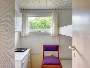 A small room with a bunk bed, a desk with drawers, a window with curtains, and a radiator. - 6 Person Holiday Home in Gorlev (Gørlev)