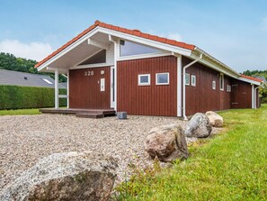 A red wooden building with a white roof, numbered 328, and a gravel driveway with rocks. - 4 Star Holiday Home in Juelsminde (Horsens)