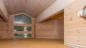 Een houten interieur met een schuine kap en een raam.