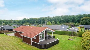 A residential property with a covered patio, a fenced yard, and a view of neighboring houses. - 4 Star Holiday Home in Juelsminde (Horsens)