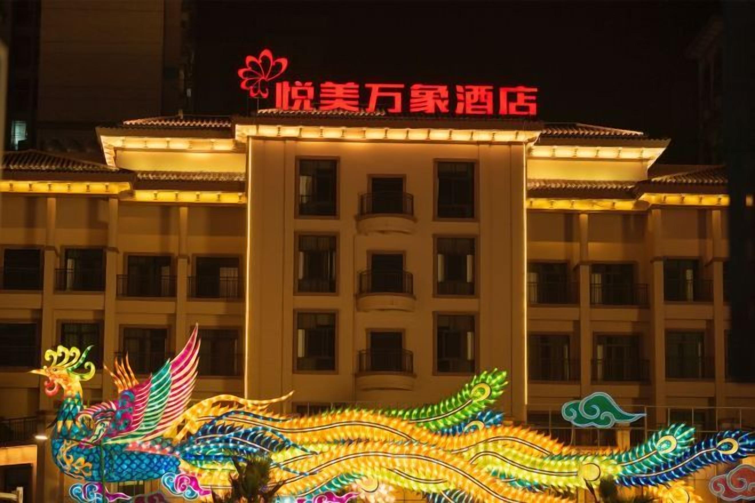 A hotel building with illuminated decorative elements and a sign above the entrance.
