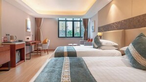 A hotel room with two beds, a desk, a chair, and a small table. - Yuemei Wanxiang Hotel (Zunyi)