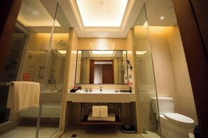 A modern bathroom with a glass-enclosed shower, a vanity with a mirror, and a toilet. - Yuemei Wanxiang Hotel (Zunyi)