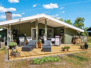 A covered outdoor seating area with wicker furniture and potted plants. - 4 Star Holiday Home in Ulfborg (Ulfborg)