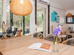 A dining area with a wooden table, chairs, and a book. - 4 Star Holiday Home in Ulfborg (Ulfborg)