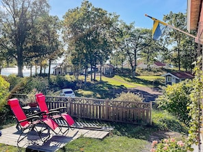 A deck with red chairs, a wooden fence, and a flag.