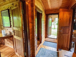 A wooden cabin interior with a desk, a door leading outside, and a window. - 6 Person Holiday Home in Blentarp (Blentarp)
