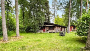 A rustic cabin with a wooden exterior, surrounded by a grassy yard and tall trees. - 6 Person Holiday Home in Blentarp (Blentarp)