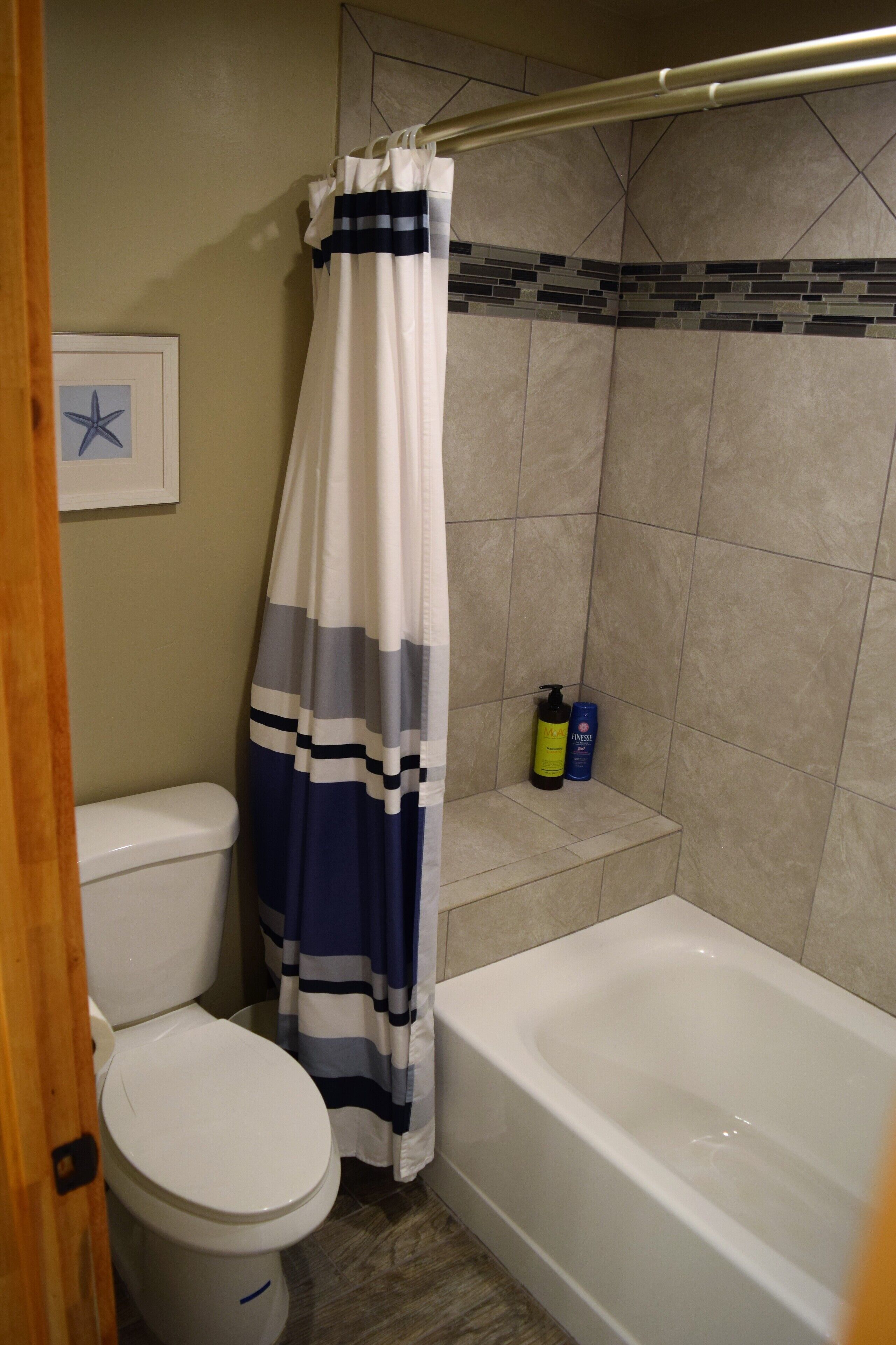 Ein Badezimmer mit Toilette, Badewanne und Duschvorhang.