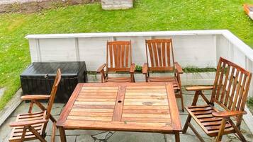 An outdoor patio with a wooden table and six chairs.
