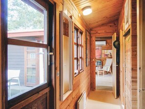 A wooden cabin interior with a narrow hallway, large windows, and a view of the outside. - 4 Person Holiday Home in Store Fuglede (Store Fuglede)
