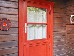 A red wooden door with a glass panel and a metal handle. - 4 Person Holiday Home in Store Fuglede (Store Fuglede)