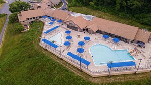 A resort with a large pool, outdoor seating, and a tennis court. - Valleywood Villa (Galena)