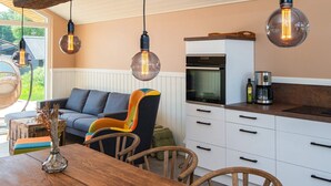 Een moderne keuken met witte kasten, een inbouwoven en een koffiezetapparaat op het aanrecht.