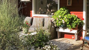 A red house with a porch, a window, and various plants. - 6 Person Holiday Home in Orno (Orno)
