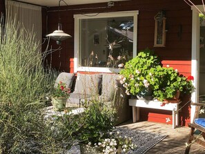 A red house with a porch, a window, and various plants. - 6 Person Holiday Home in Orno (Orno)