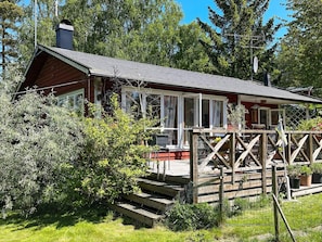 A wooden cabin with a covered porch and a chimney. - 6 Person Holiday Home in Orno (Orno)