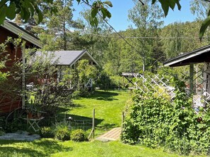 A rural property with a fenced yard, a small wooden structure, and a variety of vegetation. - 6 Person Holiday Home in Orno (Orno)