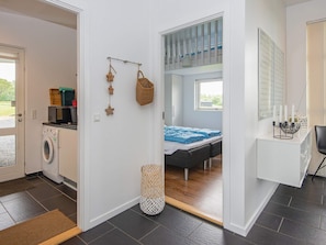 A modern bedroom with a bed, a desk, and a view of a garden through a window. - 10 Person Holiday Home in Haderslev (Årø)