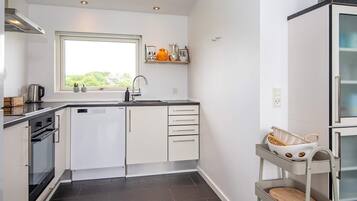 A compact kitchen with a window, built-in oven, and a small sink.