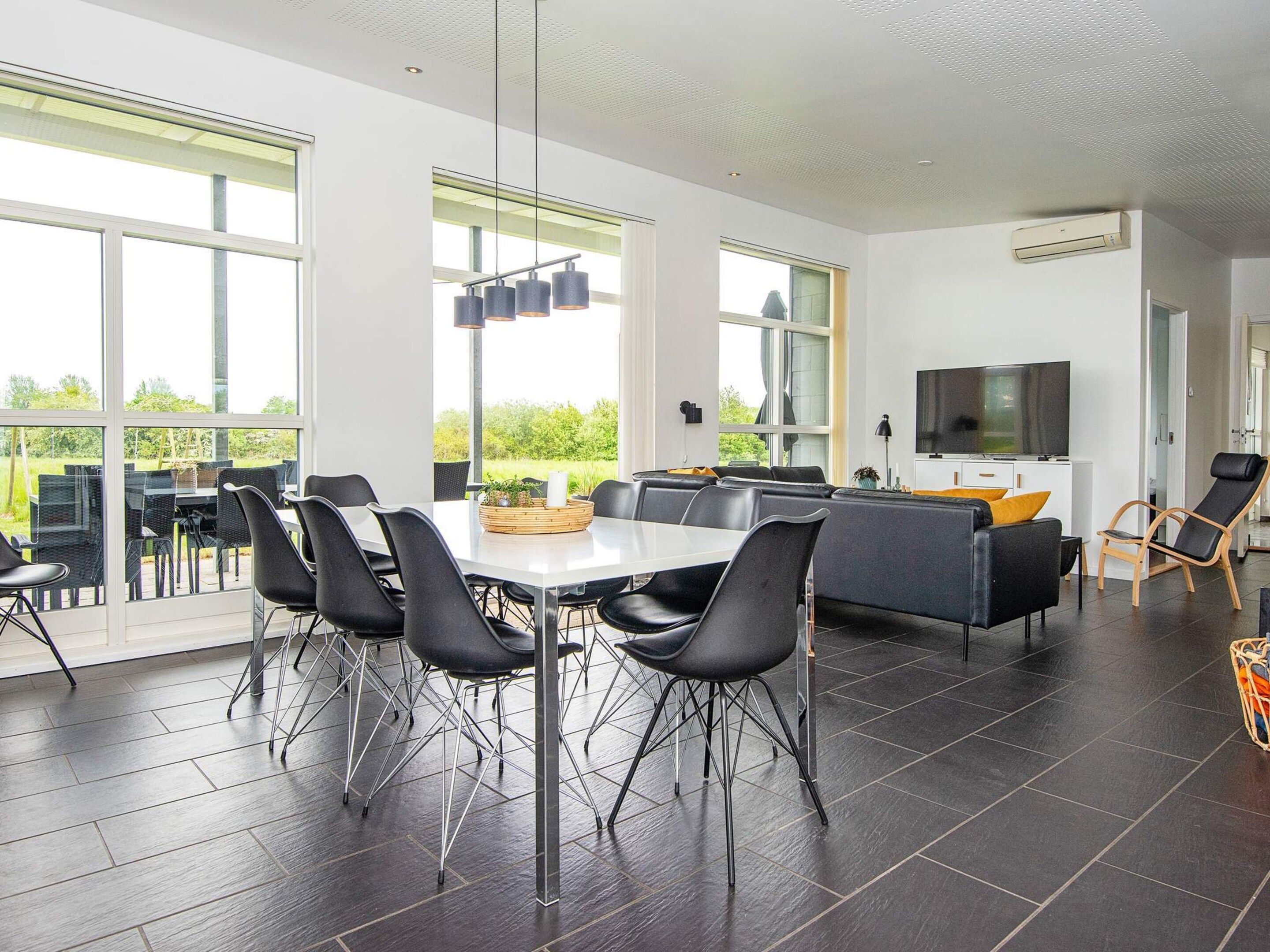 A modern interior with a dining area, seating, and a TV.
