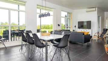 A modern interior with a dining area, seating, and a TV.