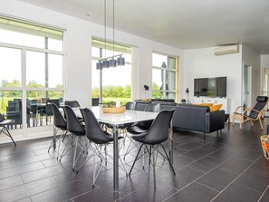 A modern interior with a dining area, seating, and a TV. - 10 Person Holiday Home in Haderslev (Årø)