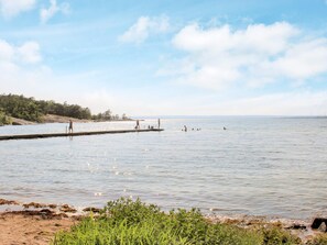 A calm lake with a pier extending into the water, surrounded by greenery and a clear sky. - 7 Person Holiday Home in Svangsta (Svangsta)