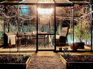 A glass-enclosed patio with a sofa, chairs, and a dining table. - 7 Person Holiday Home in Svangsta (Svangsta)