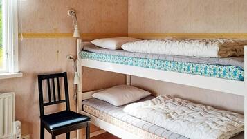 Ein Schlafzimmer mit Etagenbetten, einem Stuhl und einer Lampe.