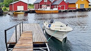 A wooden dock leading to a small white boat. - 8 Person Holiday Home in Bolandet-by Traum (Heroy)