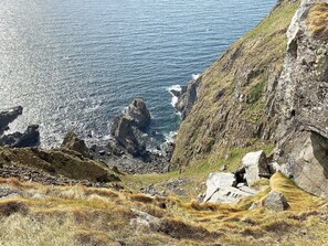 A coastal landscape with rocky cliffs and a view of the sea.