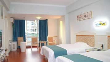 A hotel room with two beds, a desk, and a chair. There is a window with curtains, a wall-mounted TV, and a framed picture.