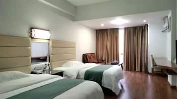 Camera d'albergo con due letti, una scrivania, una sedia, una TV e una finestra con tende.