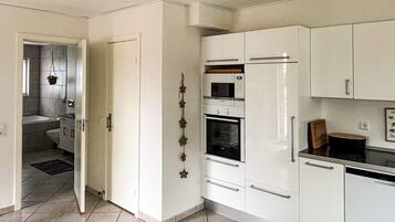 Eine Küche mit weißen Schränken, einem Backofen und einer Mikrowelle.