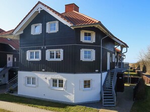 A multi-story building with a balcony and a staircase leading to the upper floor.
