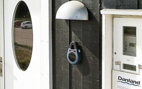 A door with a metal lock, a window with a view of a parking lot, and a Danland sign.