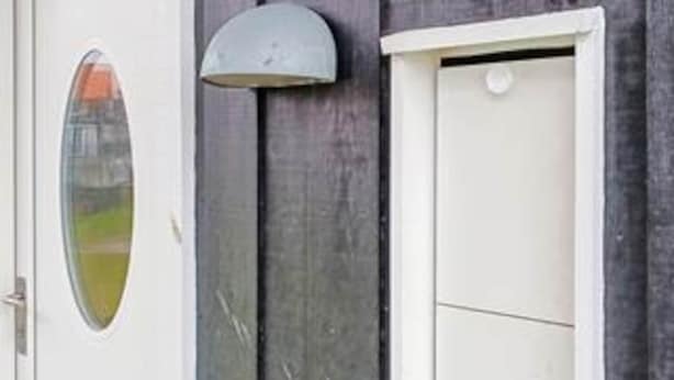 A door with a small window and a wall-mounted light fixture. - 4 Star Holiday Home in Bogense (Bogense)