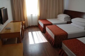 A hotel room with two beds, a wooden desk, a chair, and a TV. - Yandang Mountain Jinlaideng Hotel (Yueqing)