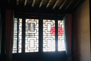 A room with a window featuring geometric patterns. - Banshan Xianke Inn (Huangshan City)