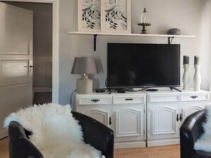 A room with a white cabinet, a flat-screen TV, a lamp, and decorative items on the wall. - 4 Star Holiday Home in Langshyttan (Langshyttan)