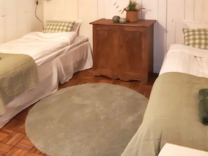 A room with two single beds, a wooden nightstand, and a round rug. - 4 Star Holiday Home in Langshyttan (Langshyttan)