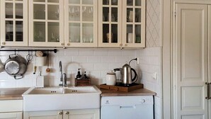 A kitchen with white cabinets, a sink, a coffee maker, and a dishwasher. - 4 Star Holiday Home in Langshyttan (Langshyttan)