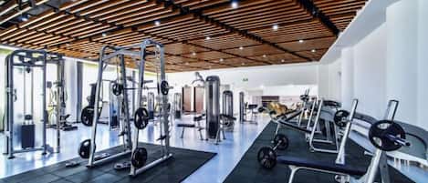 Un gimnasio con diversos equipos de ejercicio, incluyendo máquinas de pesas y pesas libres.